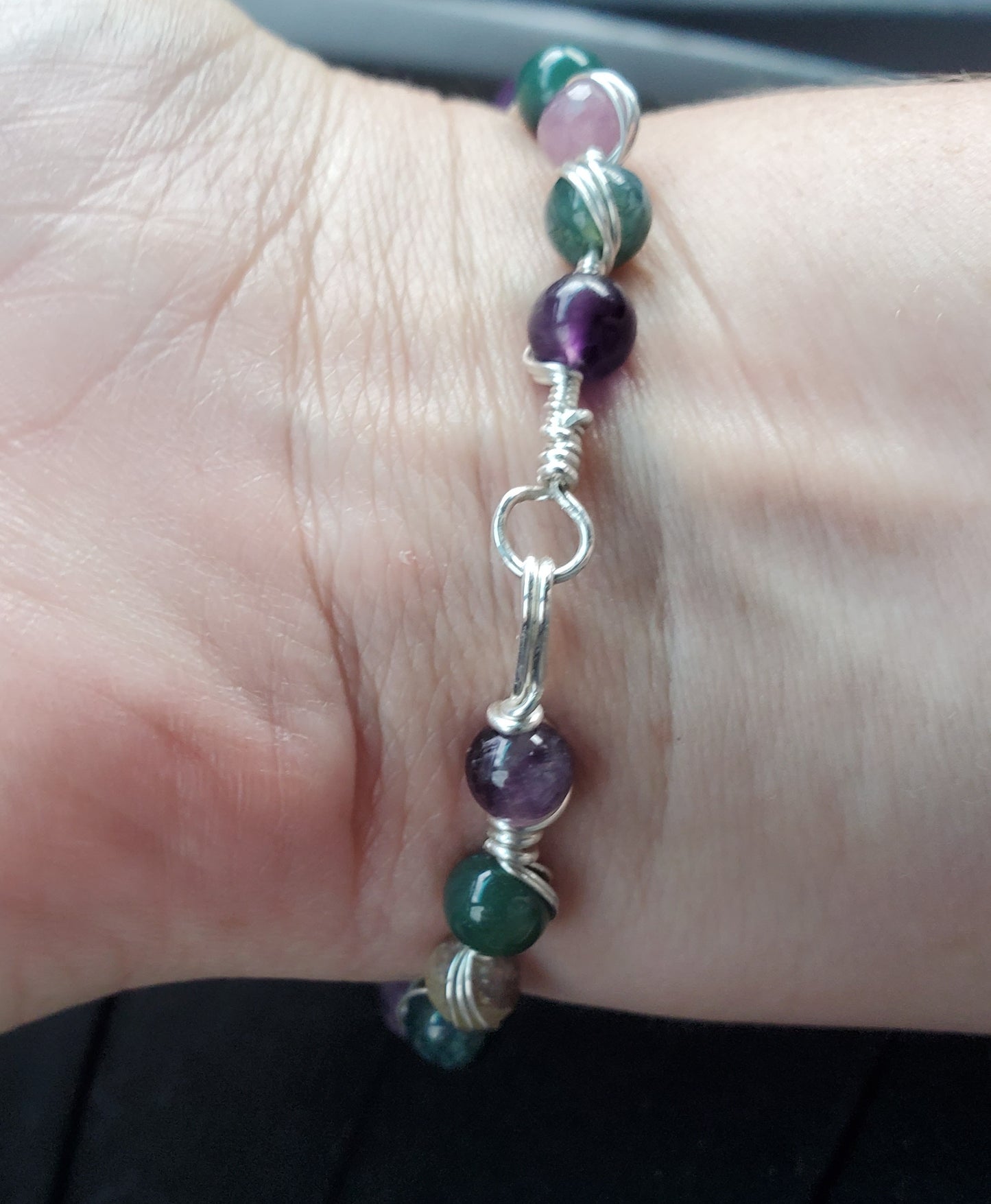 Sterling silver wire wrapped bracelet with tanzanite, tourmaline, moss agate, and amethyst.