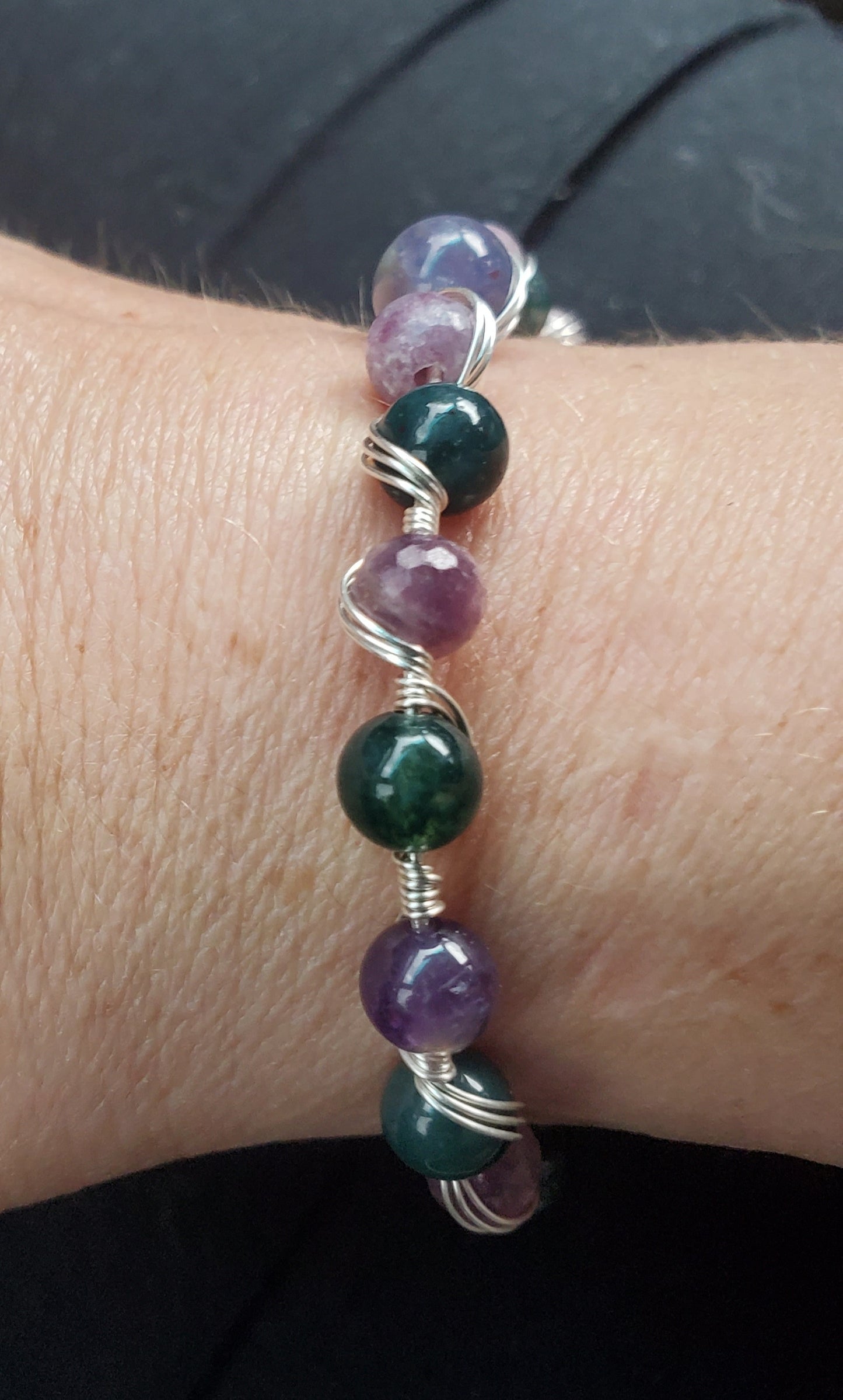 Sterling silver wire wrapped bracelet with tanzanite, tourmaline, moss agate, and amethyst.