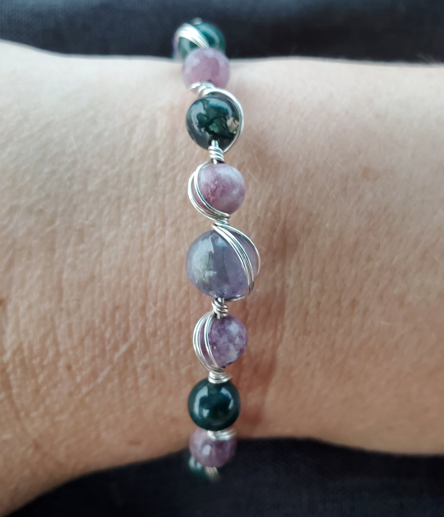 Sterling silver wire wrapped bracelet with tanzanite, tourmaline, moss agate, and amethyst.