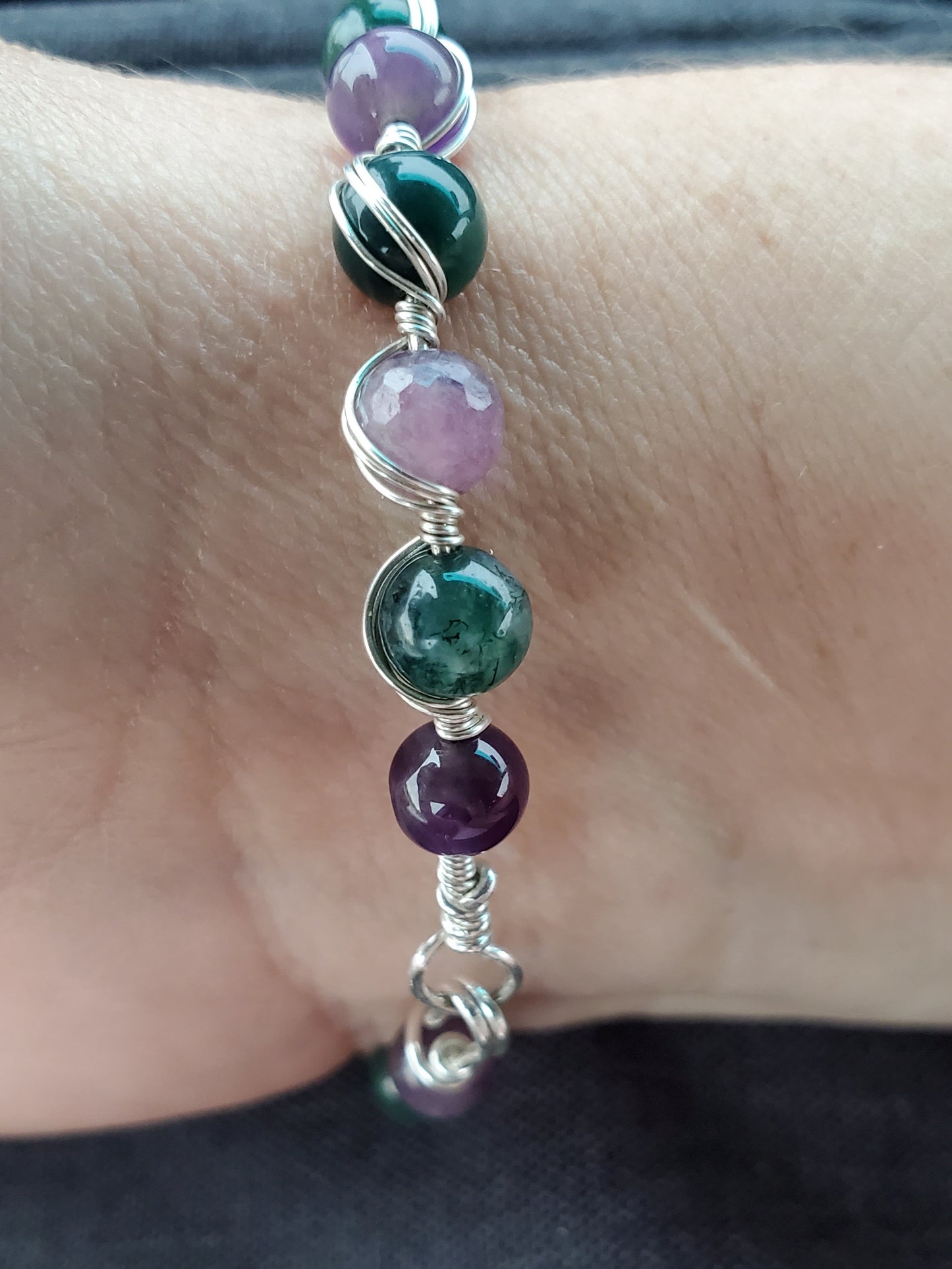 Sterling silver wire wrapped bracelet with tanzanite, tourmaline, moss agate, and amethyst.